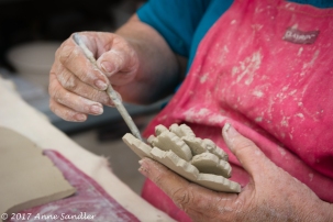 This artist is creating flowers out of left over clay.